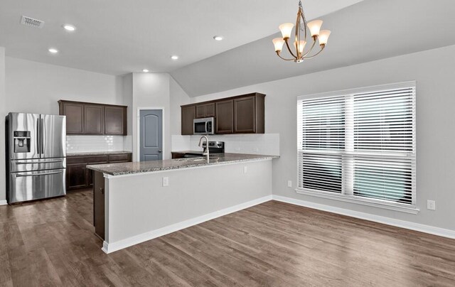 unfurnished living room featuring dark hardwood / wood-style flooring, ceiling fan with notable chandelier, and vaulted ceiling