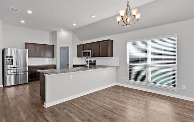 kitchen with dark hardwood / wood-style flooring, a chandelier, pendant lighting, vaulted ceiling, and appliances with stainless steel finishes