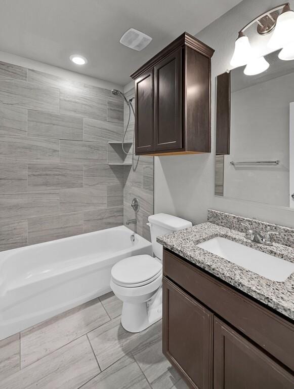 full bathroom with vanity, toilet, and tiled shower / bath