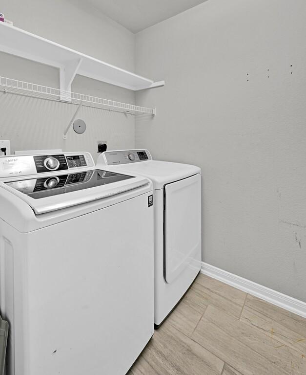 laundry area featuring washer and dryer and light hardwood / wood-style floors