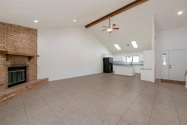 unfurnished living room featuring beam ceiling, ceiling fan, high vaulted ceiling, and a brick fireplace