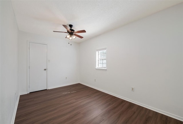 empty room featuring ceiling fan, dark wood-type flooring, and a textured ceiling