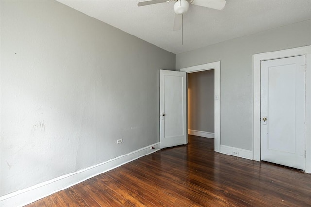 unfurnished bedroom featuring ceiling fan and dark wood-type flooring