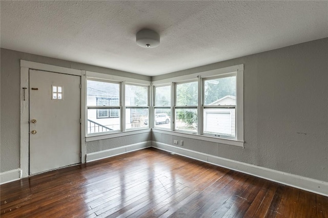 entryway with plenty of natural light, dark hardwood / wood-style flooring, and a textured ceiling