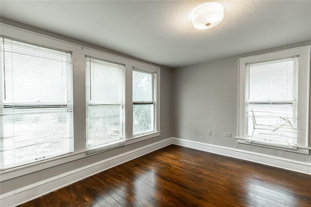 empty room featuring dark wood-type flooring and a textured ceiling