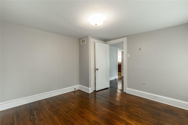 unfurnished room with dark hardwood / wood-style flooring and a textured ceiling