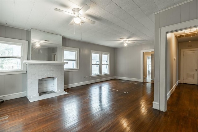 unfurnished living room featuring a fireplace, dark hardwood / wood-style flooring, and ceiling fan