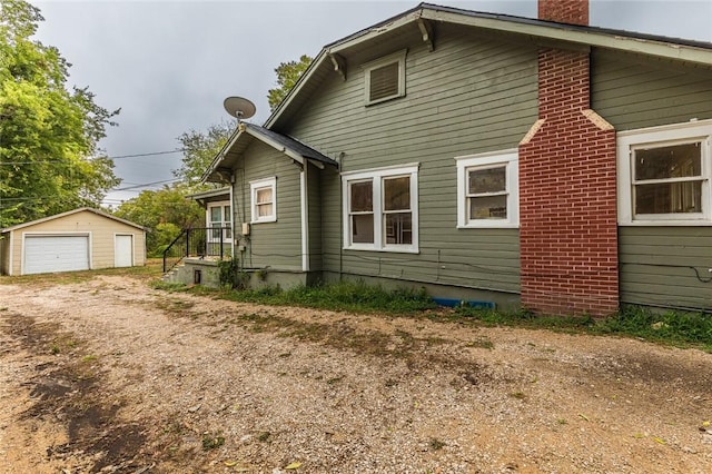 rear view of house with a garage and an outdoor structure