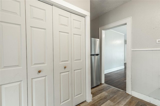 hall featuring hardwood / wood-style flooring and a textured ceiling