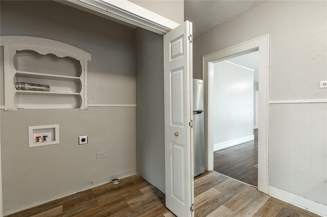 clothes washing area featuring washer hookup, a textured ceiling, hardwood / wood-style flooring, and electric dryer hookup