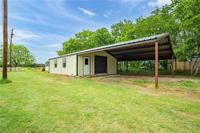 view of outdoor structure with an outbuilding, fence, and driveway