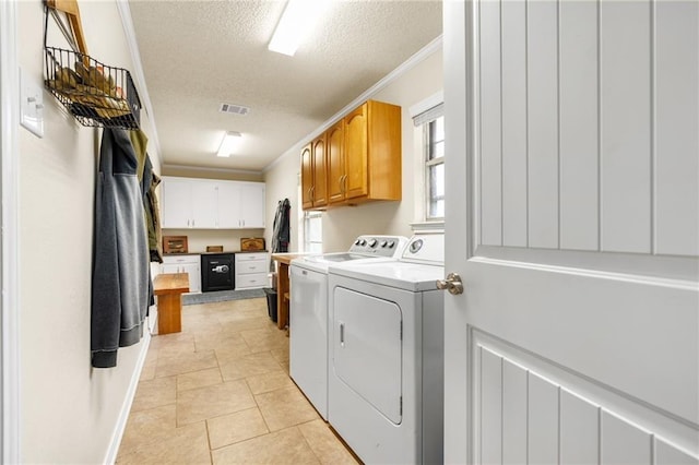 laundry area featuring visible vents, ornamental molding, a textured ceiling, cabinet space, and washing machine and clothes dryer