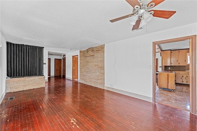 unfurnished living room with ceiling fan, dark wood-type flooring, and a textured ceiling