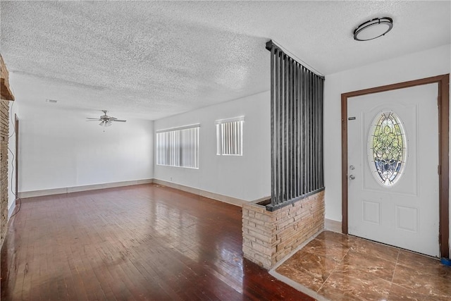 entrance foyer with a textured ceiling, dark hardwood / wood-style floors, and ceiling fan