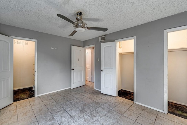 unfurnished bedroom with a ceiling fan, visible vents, a textured ceiling, and baseboards