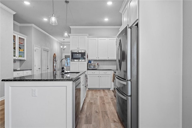 kitchen with white cabinets, hanging light fixtures, and appliances with stainless steel finishes