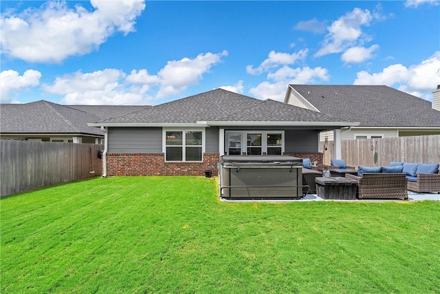 back of house featuring a lawn, an outdoor living space, and a hot tub