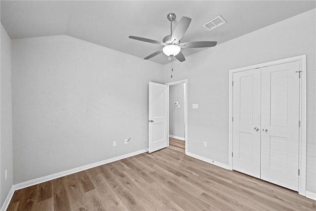 unfurnished bedroom featuring a closet, ceiling fan, light hardwood / wood-style flooring, and lofted ceiling