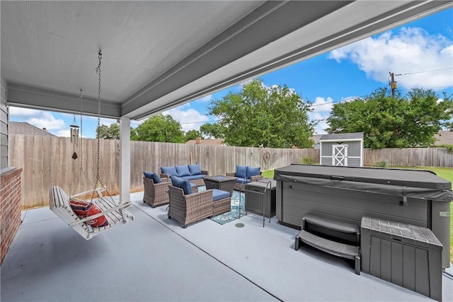 view of patio featuring an outdoor hangout area, a hot tub, and a storage unit