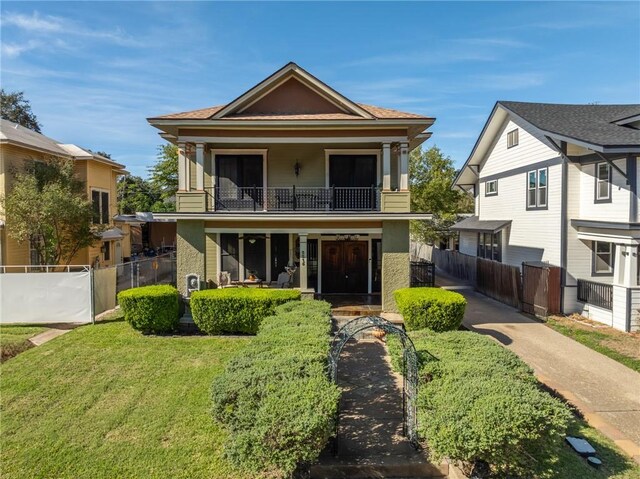 view of front of property with a balcony and a front lawn