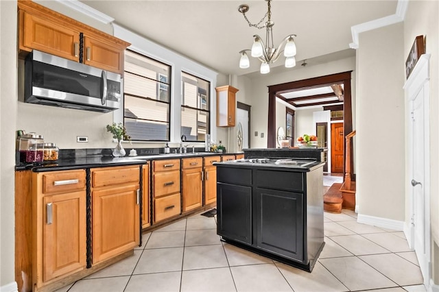 kitchen with an inviting chandelier, crown molding, decorative light fixtures, light tile patterned flooring, and stainless steel appliances