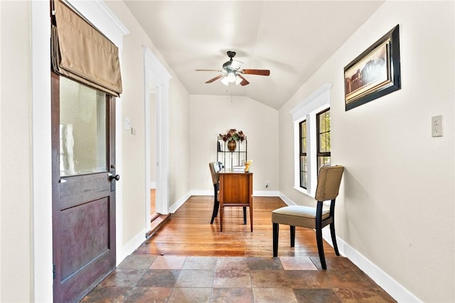 interior space with lofted ceiling, dark wood-style flooring, ceiling fan, and baseboards