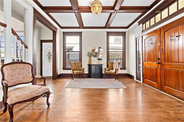 foyer entrance featuring beam ceiling, wood-type flooring, coffered ceiling, and a notable chandelier