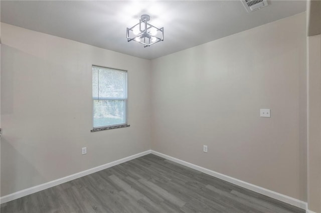 unfurnished room featuring hardwood / wood-style floors and a notable chandelier