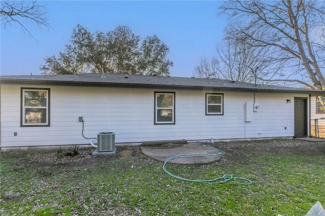 back of property with central AC and a yard