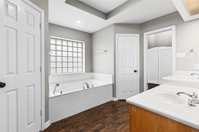 bathroom with a tub to relax in, vanity, and hardwood / wood-style flooring