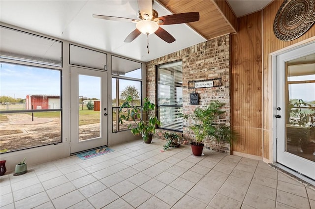 unfurnished sunroom featuring ceiling fan