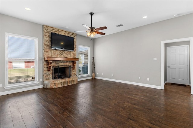 unfurnished living room with ceiling fan, a fireplace, and dark hardwood / wood-style floors