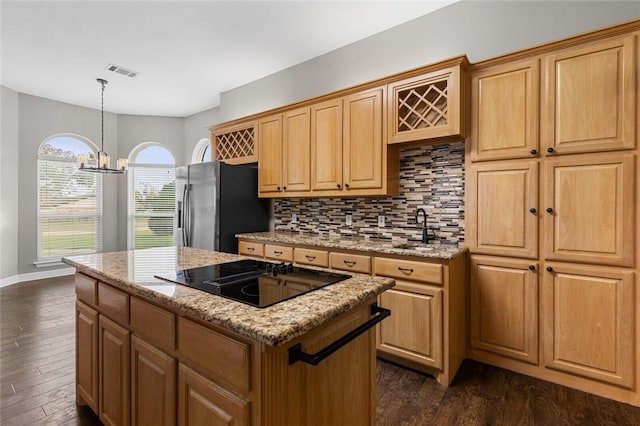 kitchen with a center island, black electric stovetop, sink, stainless steel fridge, and dark hardwood / wood-style flooring