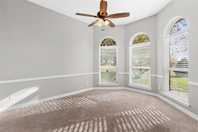 carpeted empty room featuring ceiling fan