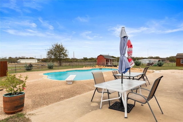 view of pool featuring a diving board and a patio area