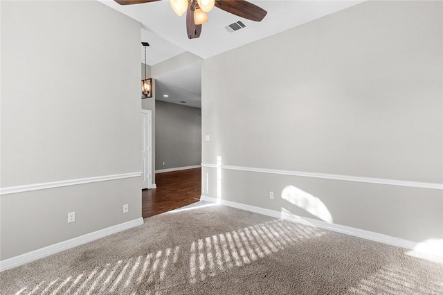 spare room with ceiling fan with notable chandelier and carpet floors