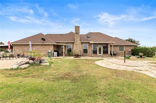 back of property with a lawn and a patio area