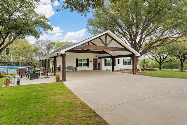 view of property's community featuring a lawn, a patio area, and a swimming pool