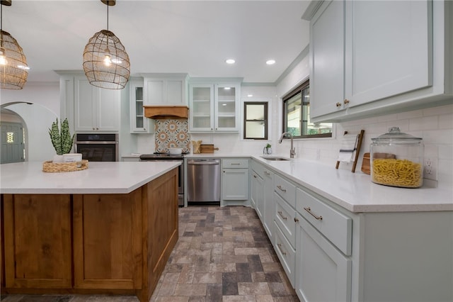 kitchen with decorative light fixtures, white cabinetry, sink, and appliances with stainless steel finishes