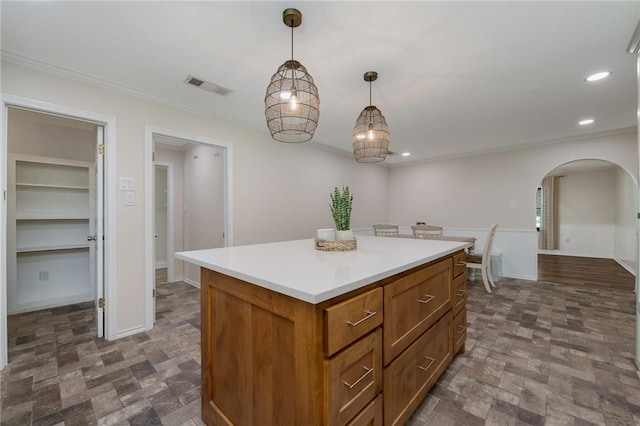 kitchen with a center island, decorative light fixtures, and ornamental molding