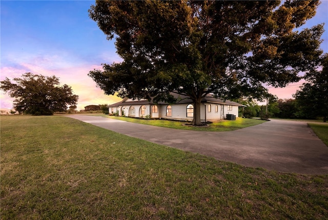 view of front of property featuring a lawn and central AC unit