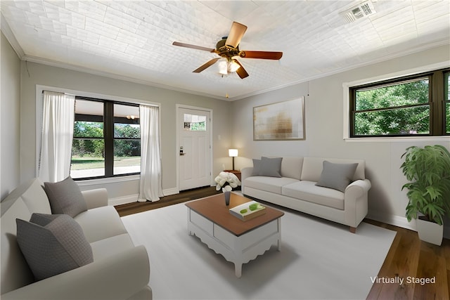 living room featuring dark hardwood / wood-style flooring, ornamental molding, and a wealth of natural light