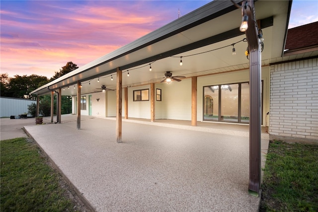 patio terrace at dusk featuring ceiling fan