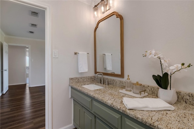 bathroom featuring hardwood / wood-style floors, vanity, and ornamental molding