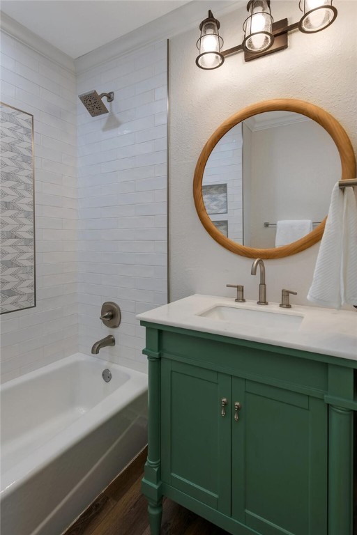 bathroom with vanity, tiled shower / bath, and hardwood / wood-style flooring