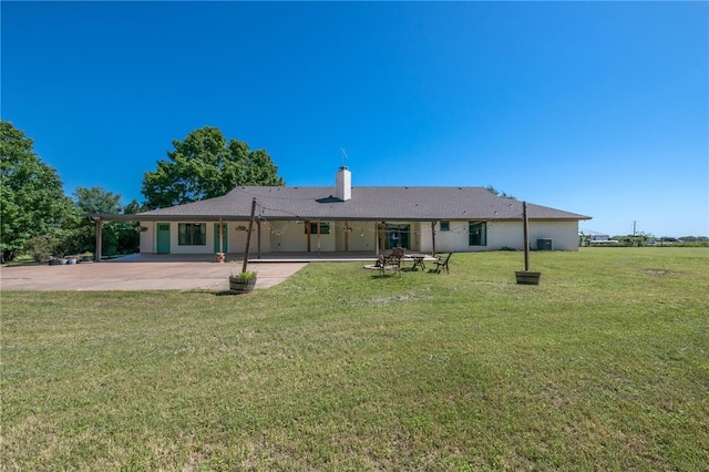 back of property featuring a yard and a patio