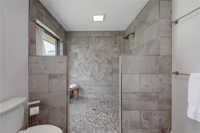 bathroom featuring tiled shower and toilet