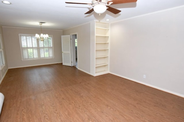 unfurnished room with built in shelves, crown molding, baseboards, ceiling fan with notable chandelier, and wood finished floors