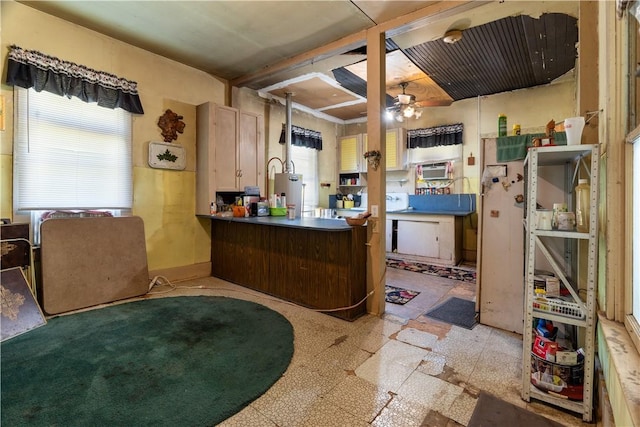 kitchen with kitchen peninsula, gas water heater, and ceiling fan