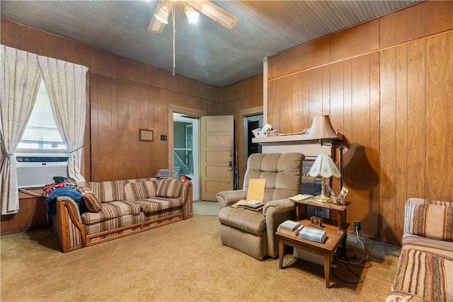 carpeted living room featuring ceiling fan, cooling unit, and wood walls